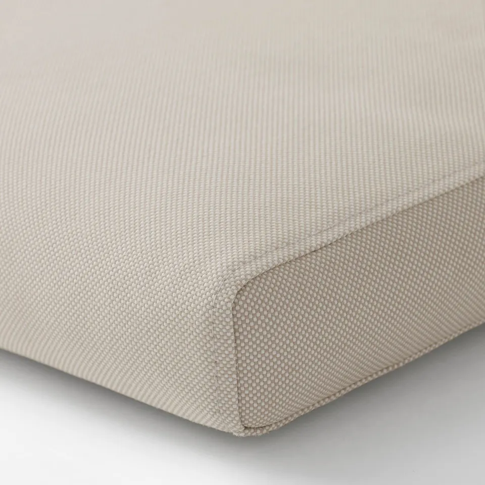 Beige, textured cushion cover with a stitched edge, showcasing high-quality material.