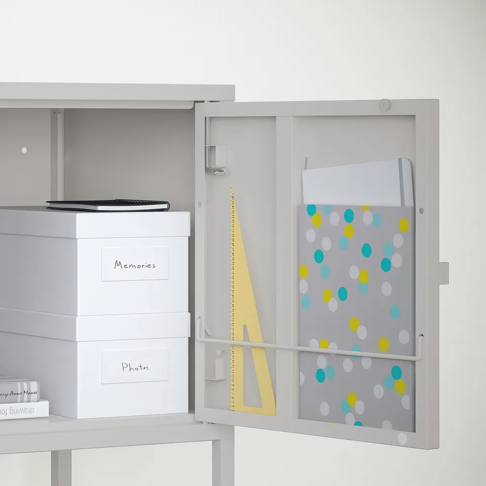 White cabinet with doors open, revealing organisation for photos and memories with a colourful patterned divider.