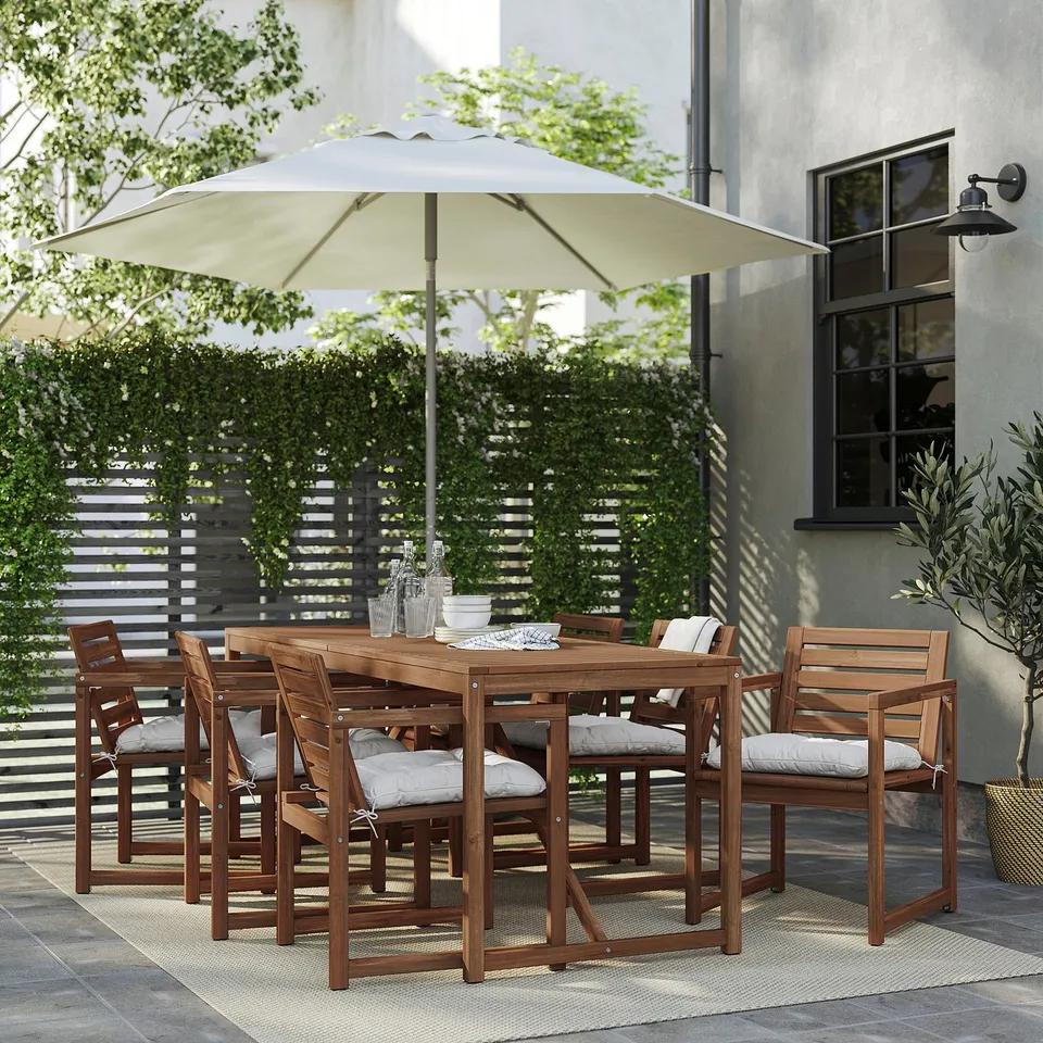 Patio with NÄMMARÖ table, chairs, and umbrella. Table set with dishes and glasses.