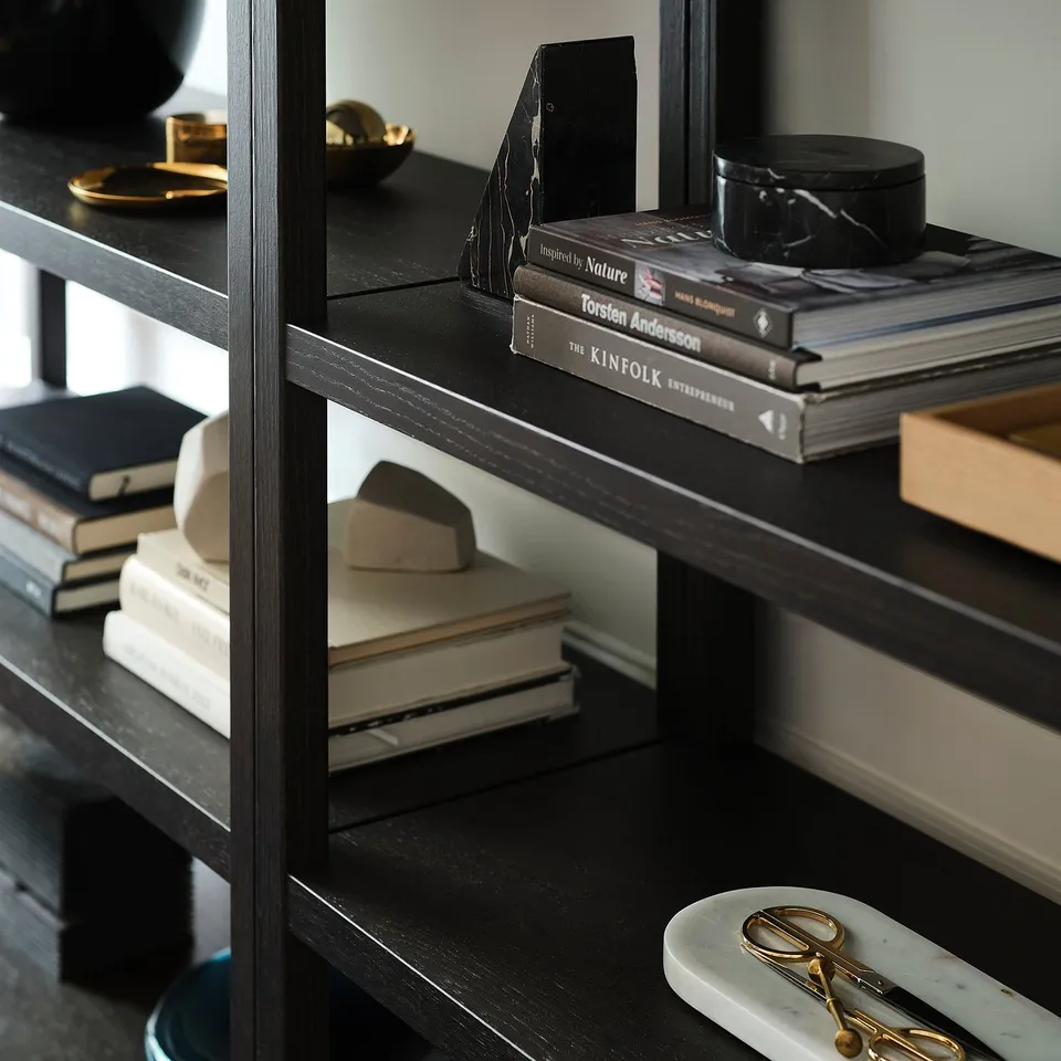 Shelf unit displays books, decor, and accessories. Wide shelves and adjustable feet for stability.