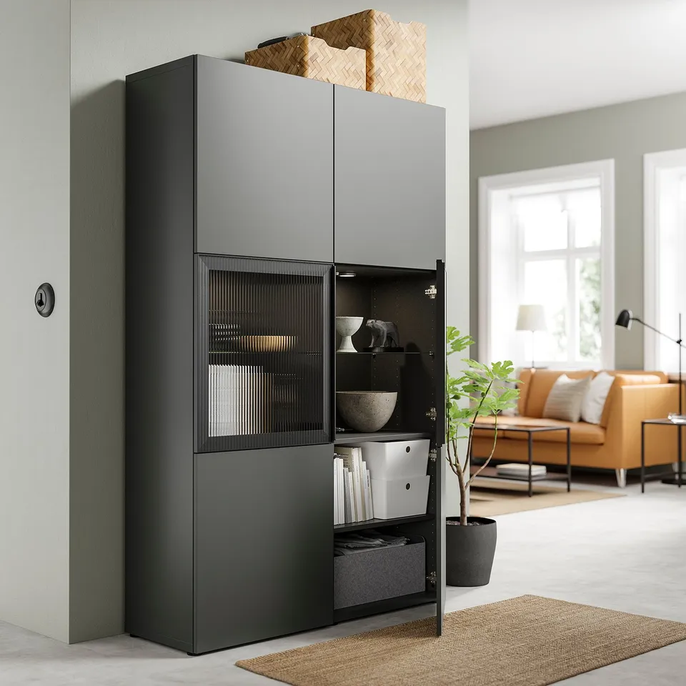Grey BESTÅ storage with shelves, drawers & wicker basket near yellow sofa & plant.