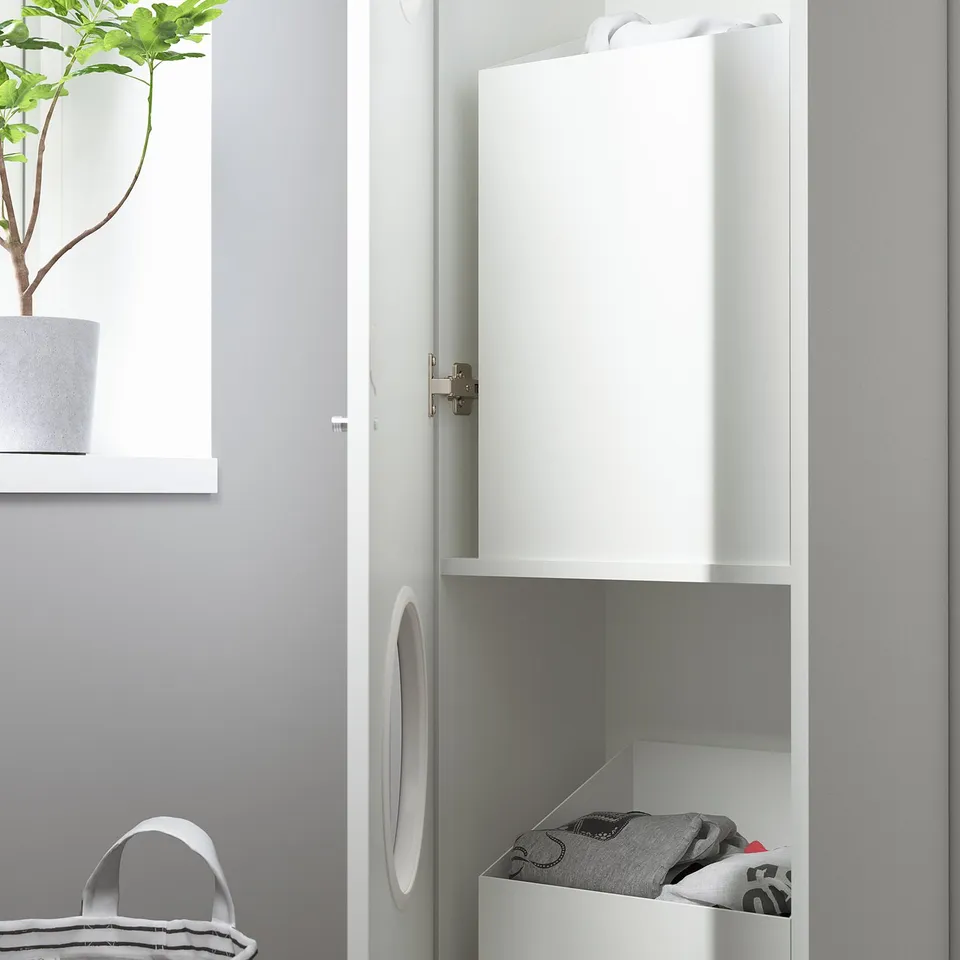 White cabinet with open door and sorted laundry. Potted plant on shelf beside it.