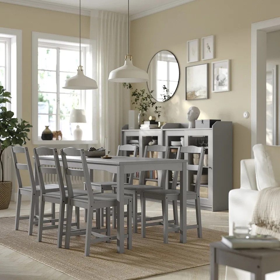 Modern dining set with rectangular table, 6 chairs, and rug. Surrounded by windows with curtains, pendant lights, and mirrored wall.