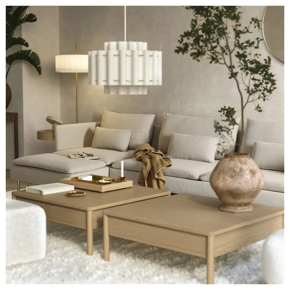 Modern living room with beige SÖDERHAMN sofa bed, wooden coffee table, and unique white pendant light. Decor includes plants and a beige vase.
