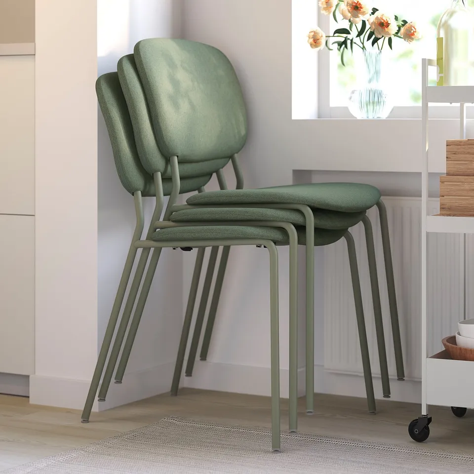 Three green LISABO chairs stacked neatly, showcasing their space-saving design. Suitable for home use with a sturdy, upholstered seat for comfort.