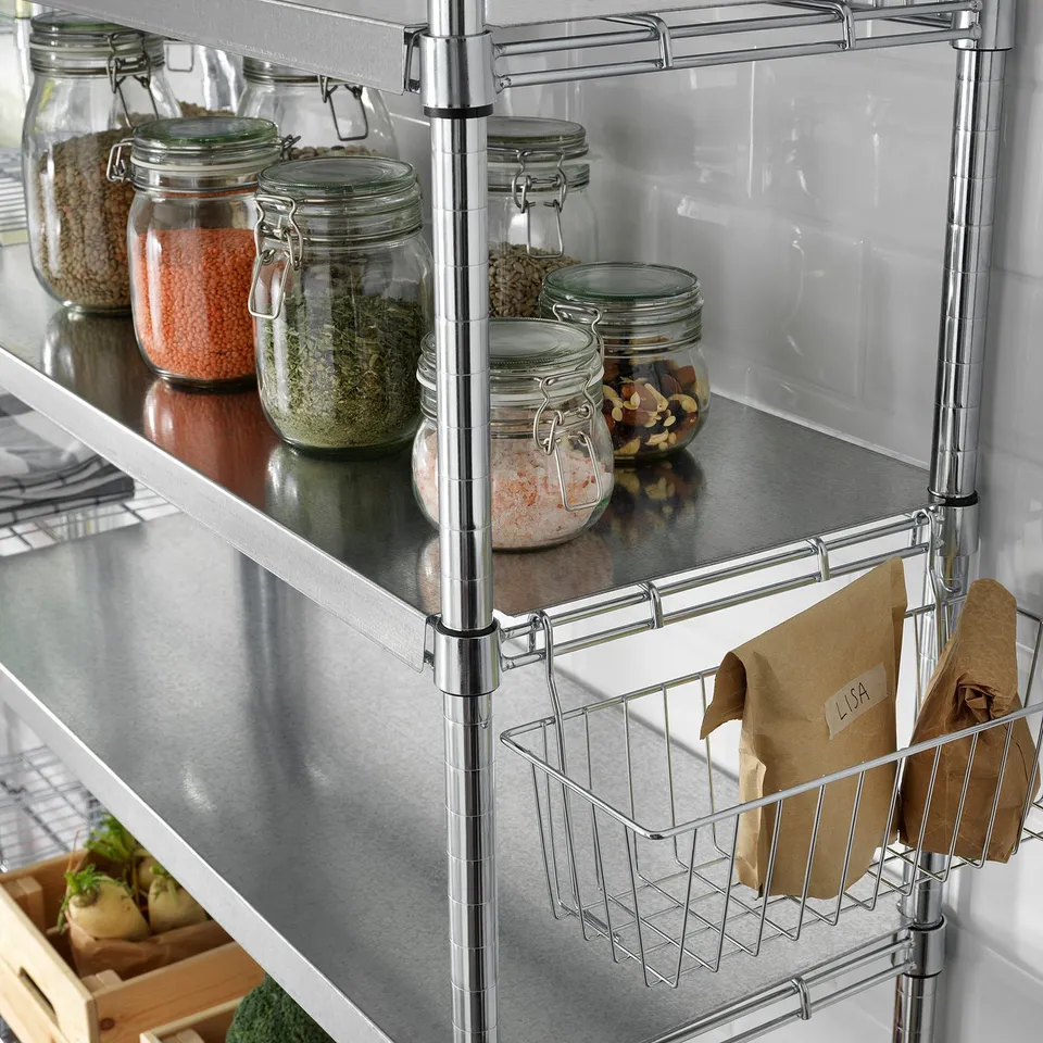 Metal shelves with glass jars of dried beans, herbs, spices, and nuts; paper bags on wire baskets.