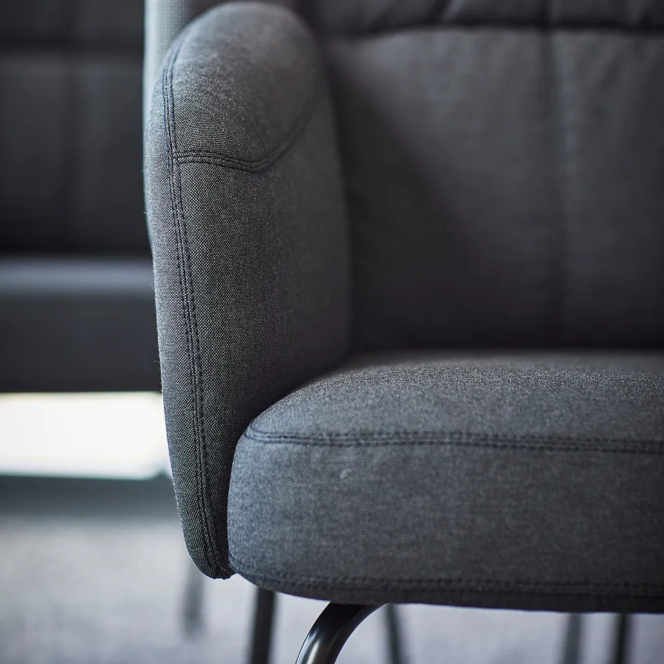 The BINGSTA armchair in grey, featuring plush upholstery, rounded armrests, and a curved back for comfort.