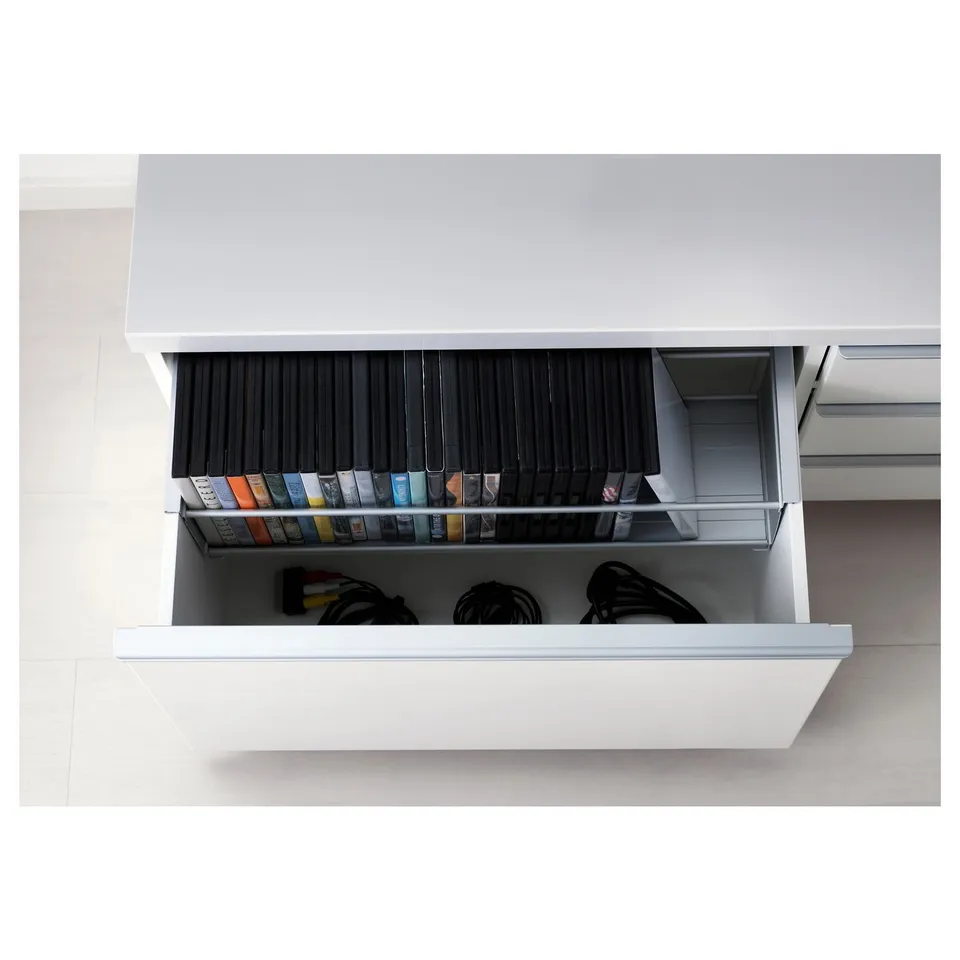 Open bestå tv bench with drawers showing organised electronics, cables, and game accessories.