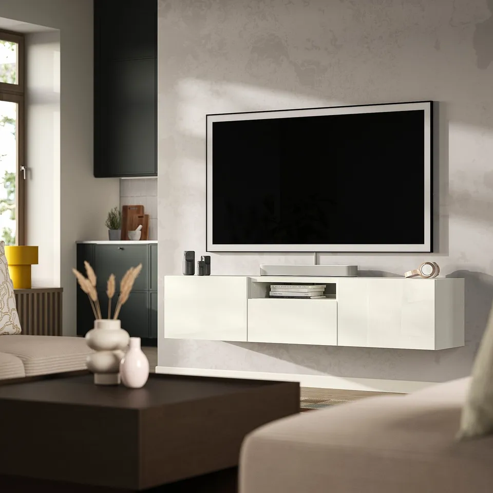 Contemporary living room with flat-screen tv on BESTÅ tv bench, cream sofa, and coffee table with vase.