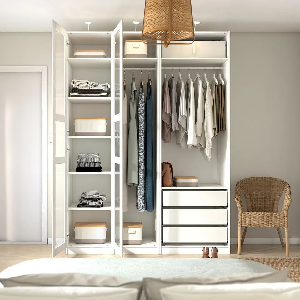 Open white wardrobe with clothes hangers, shelves, and drawers; neatly organised.