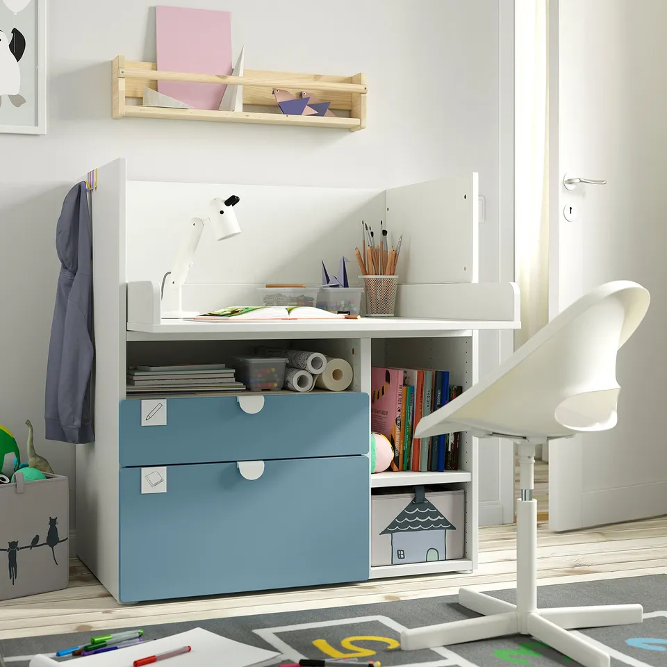Kids study area: white desk with blue drawers, art supplies, and chair. Well-lit, organised, and spacious.