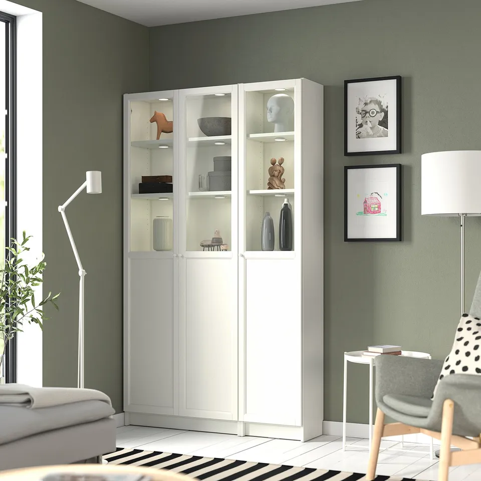 Modern living room with BILLY bookcase, polka-dot chair, sofa, and wall decor.