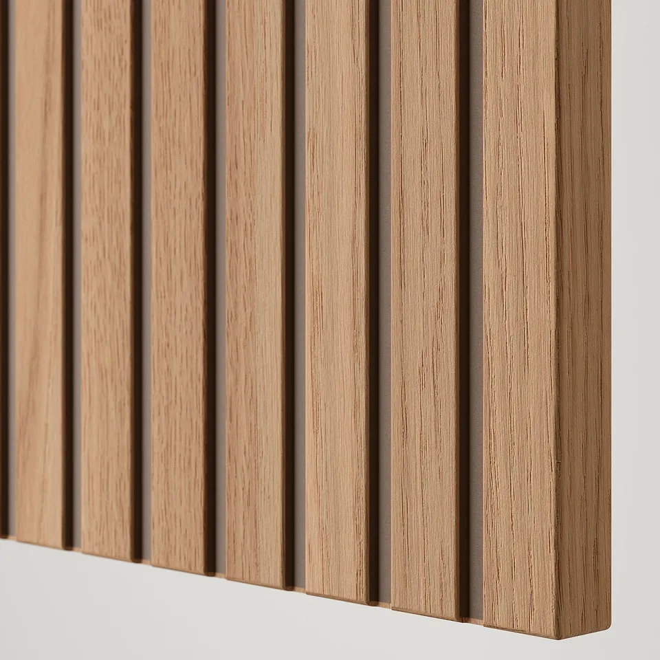Close-up of a wooden furniture door with vertical oak veneer, showcasing high-quality craftsmanship.