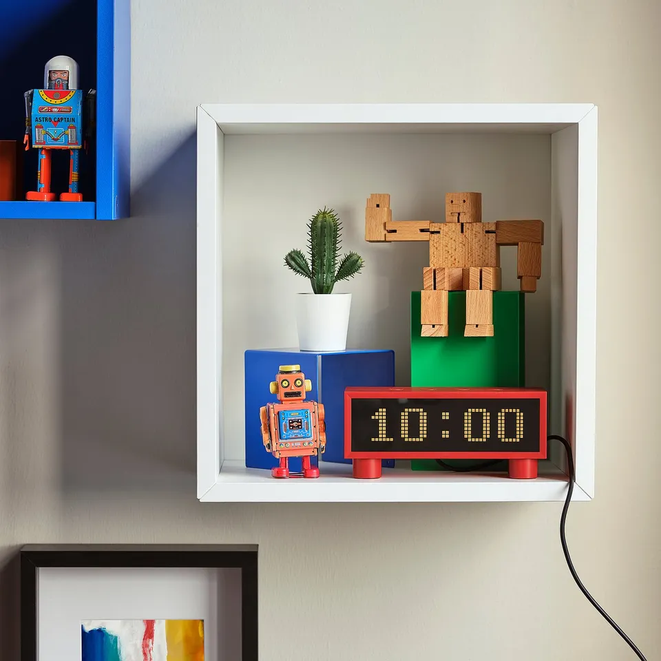 White shelf with KORTLINJE clock, cactus, wooden robot, retro toy.