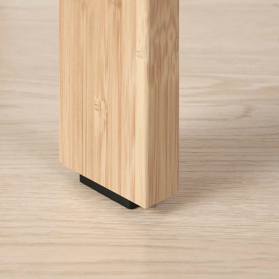 Close-up of a bamboo coffee table leg with a black metal connector, showcasing sturdy construction and smooth finish.