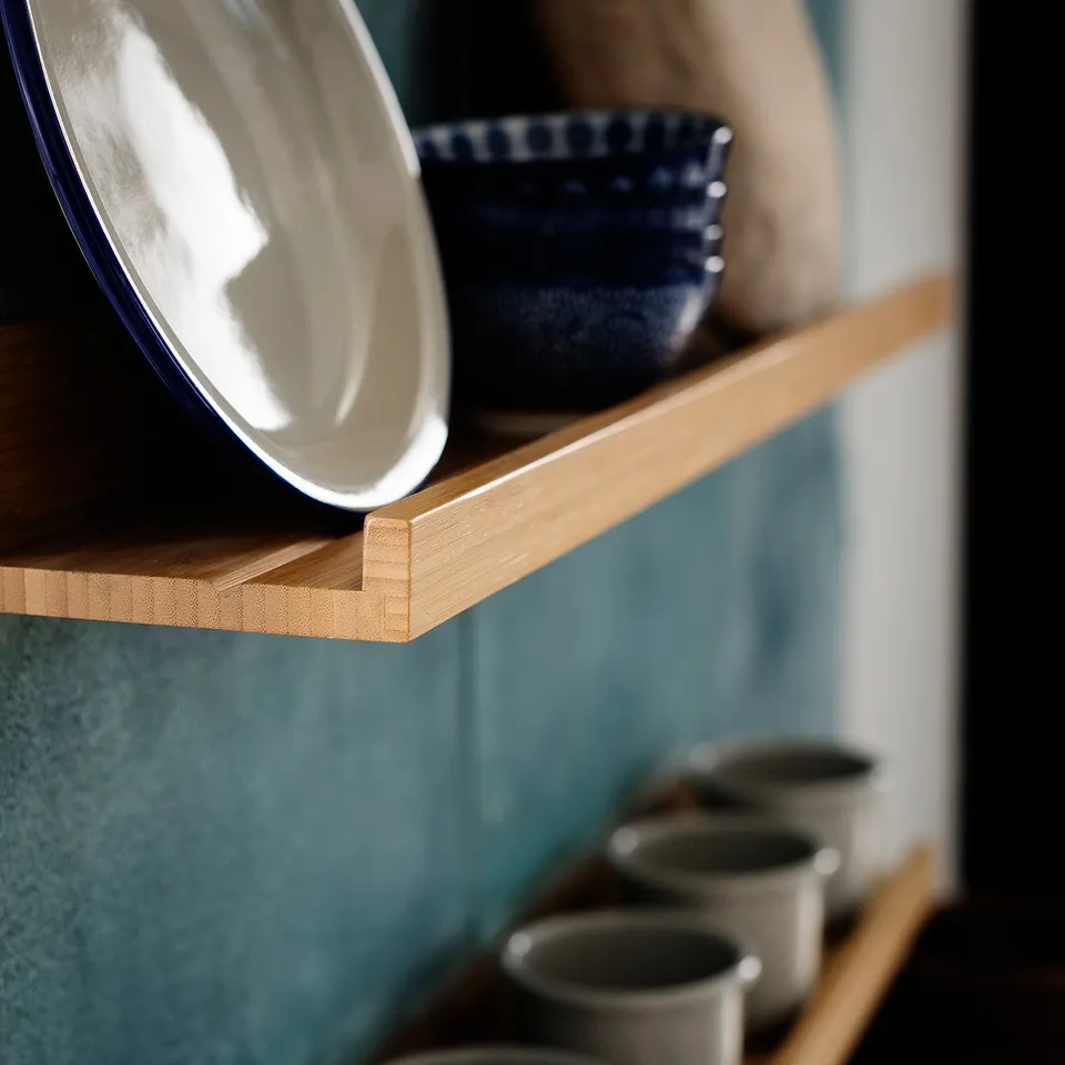 Wooden shelf with white and blue dishes, bamboo material.