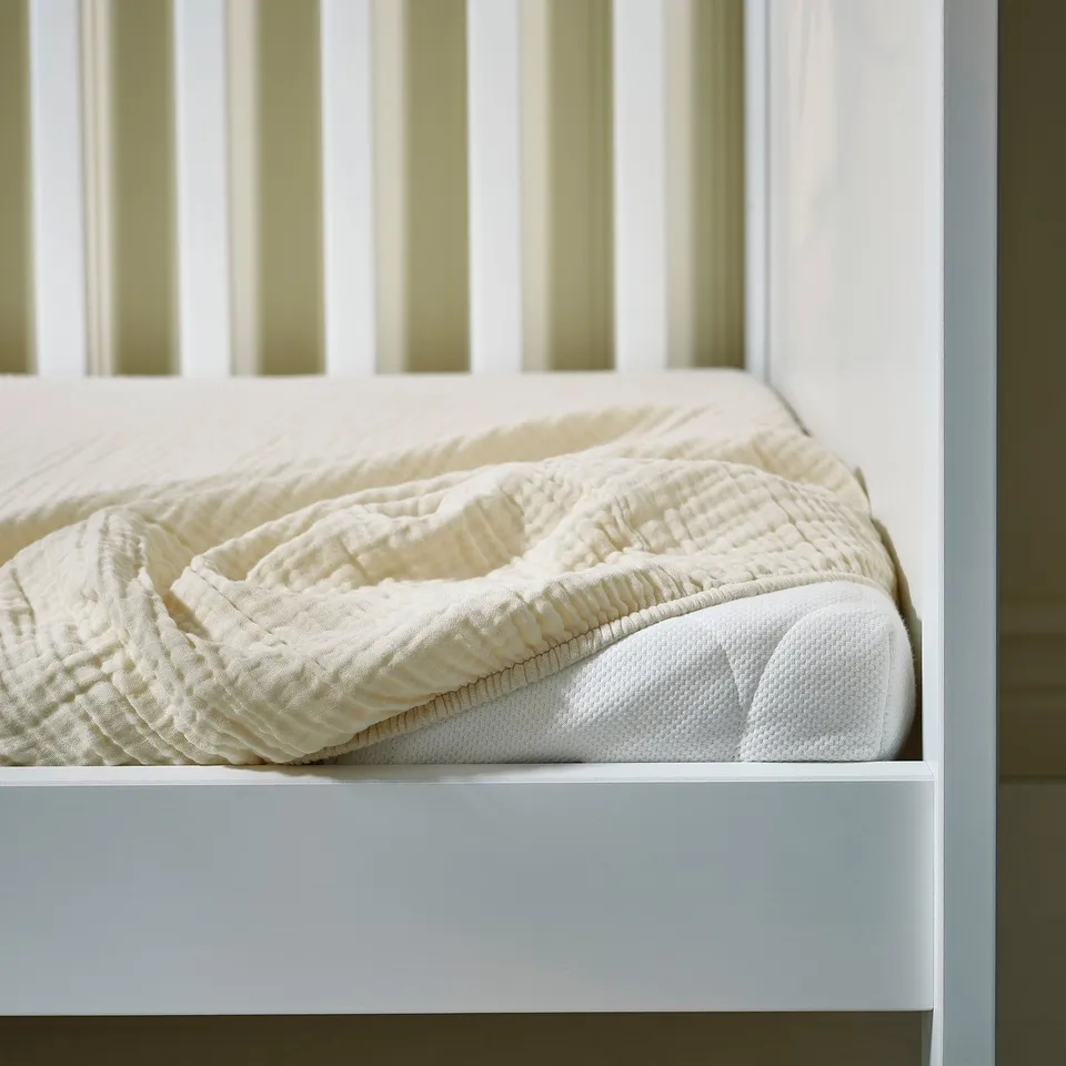 Bed's organic cotton sheets on white frame, showing clean, simple design for baby.