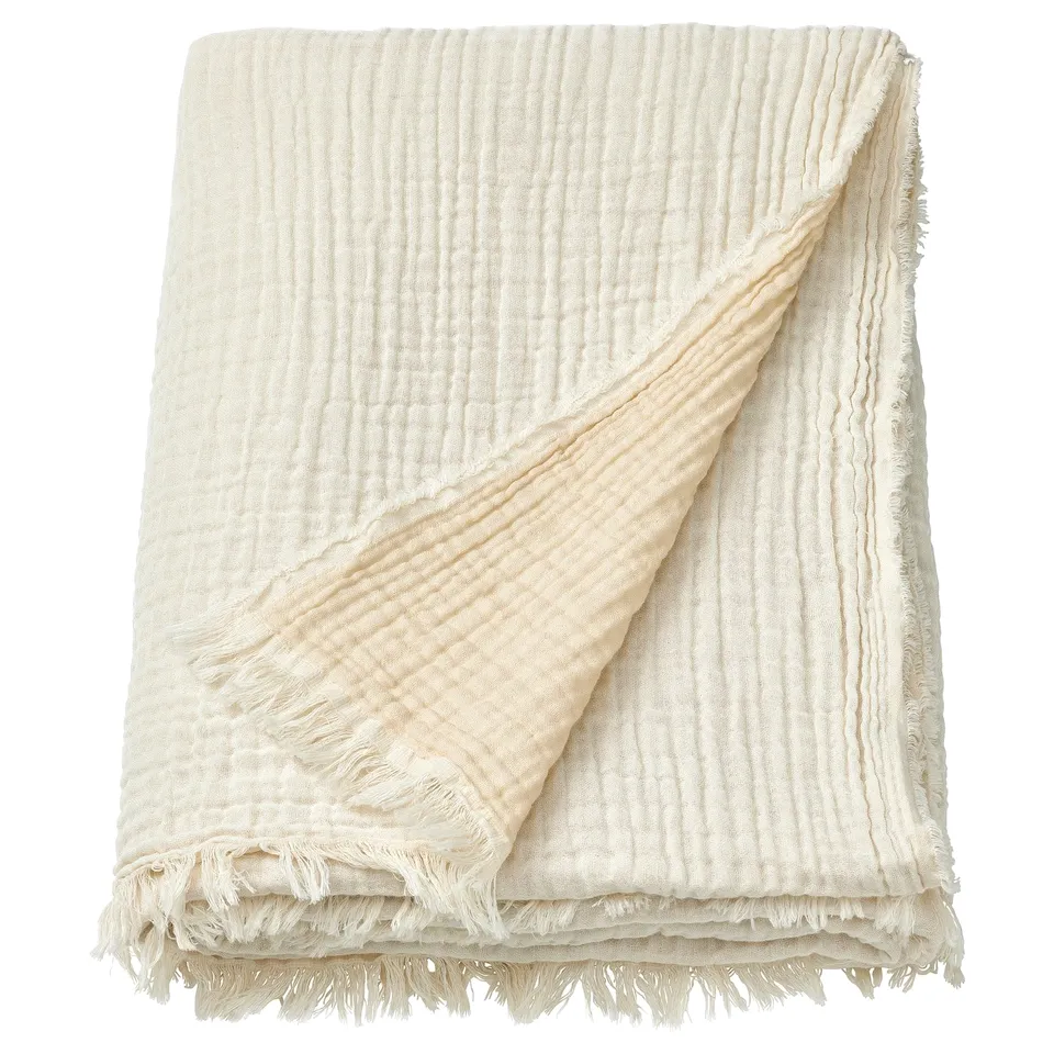 VALLKRASSING cream throw blanket, soft crinkled cotton muslin with raw edges.