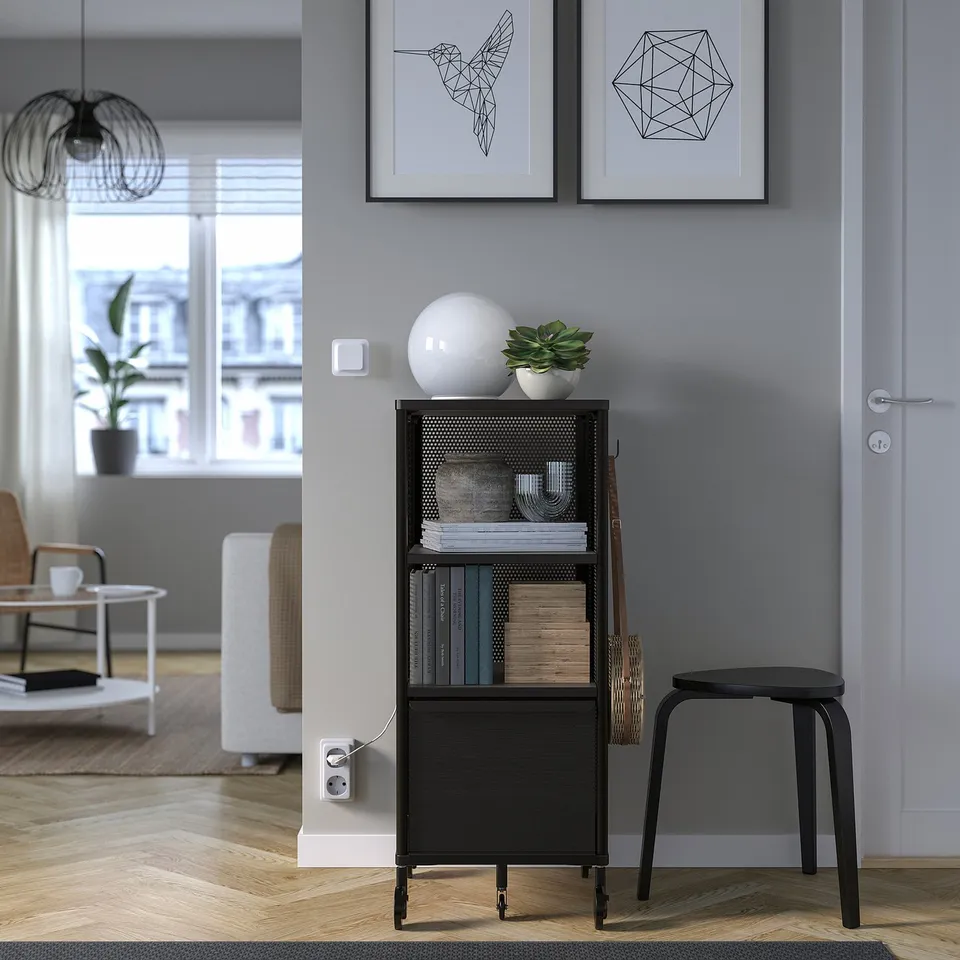 Modern room with black BEKANT storage, books, plant, and decor.