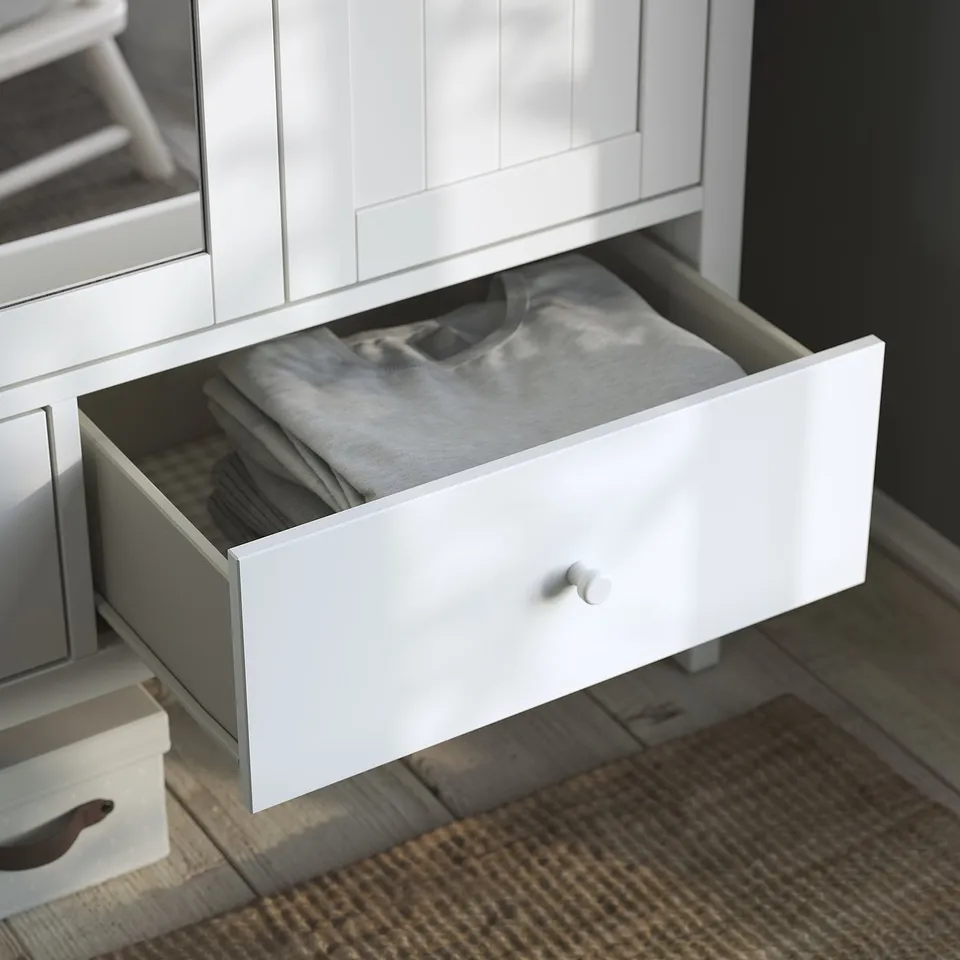 White wooden GULLABERG wardrobe drawer open, neatly folded clothes inside.