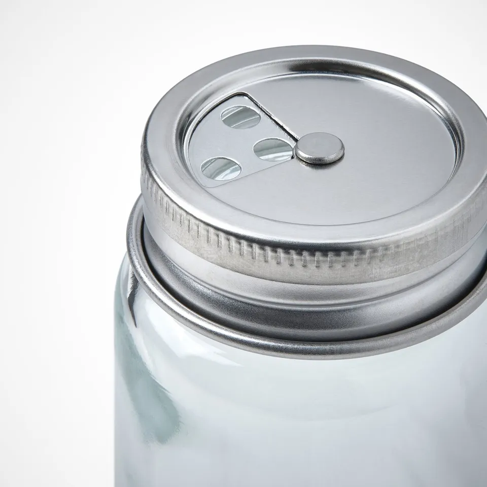 Clear glass jar with metal lid, featuring three small holes and a secure closure, perfect for storing and dispensing items.