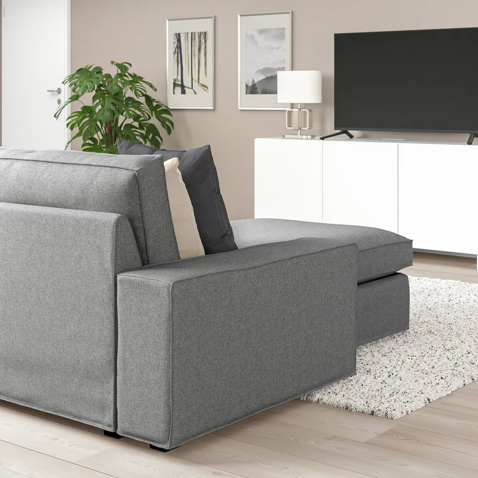 Cosy KIVIK grey sofa with chaise, large cushions, soft fabric, in modern living room with tv.