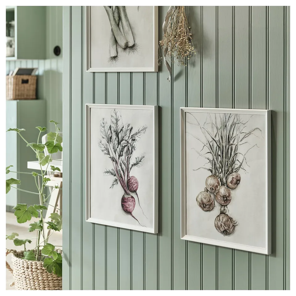 Three vegetable artworks hang on green wall. Left: potted plant. Centre: beet illustration. Right: onion drawing.