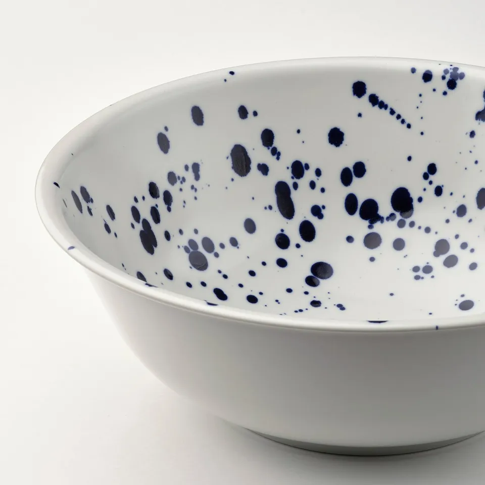 White bowl with blue splatter, clean design