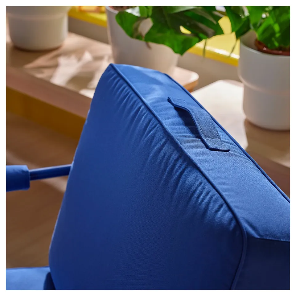 Close-up of a modern, deep-blue BRÄNNBOLL lounge chair, showcasing its high-quality fabric and sturdy design.