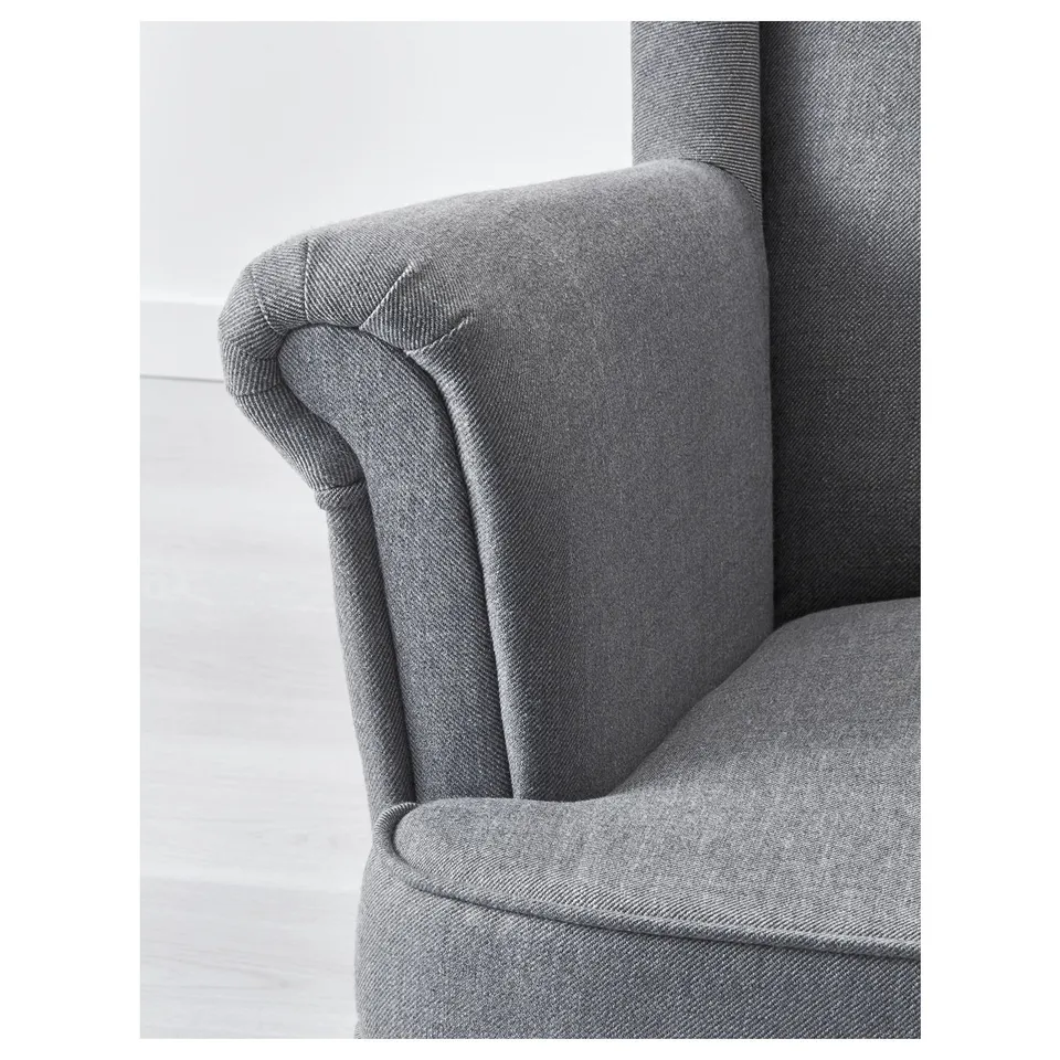 Grey fabric wingback chair showcasing quality craftsmanship, plush cushions, and detailed stitching, designed for comfort.