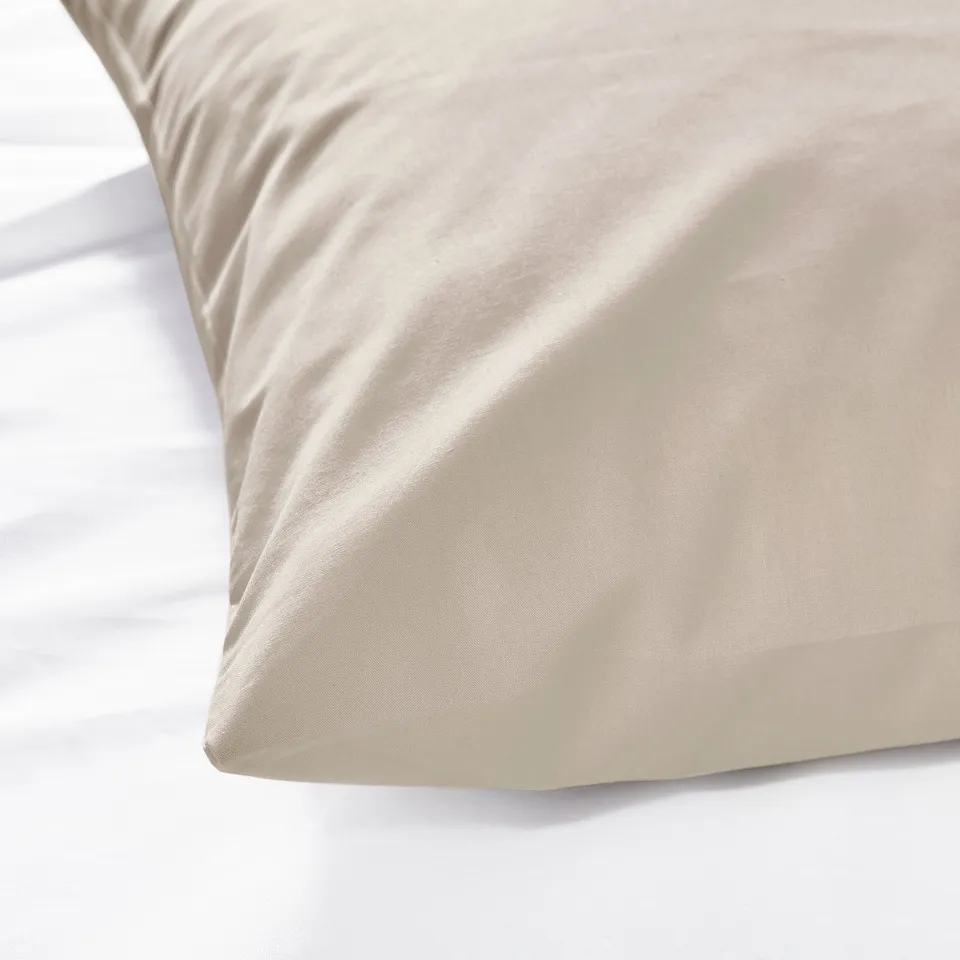 A smooth beige cotton pillowcase with an elegant curtain, showcasing its soft, high-quality texture.