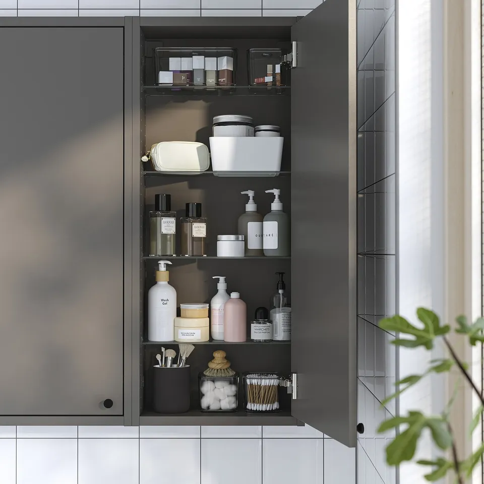 Open dark grey wall cabinet showing organised toiletries on shelves.