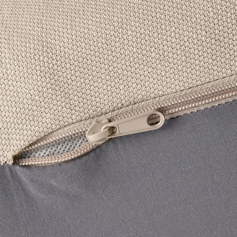 Close-up of zip on beige fabric, showing quality stitching and durable material.