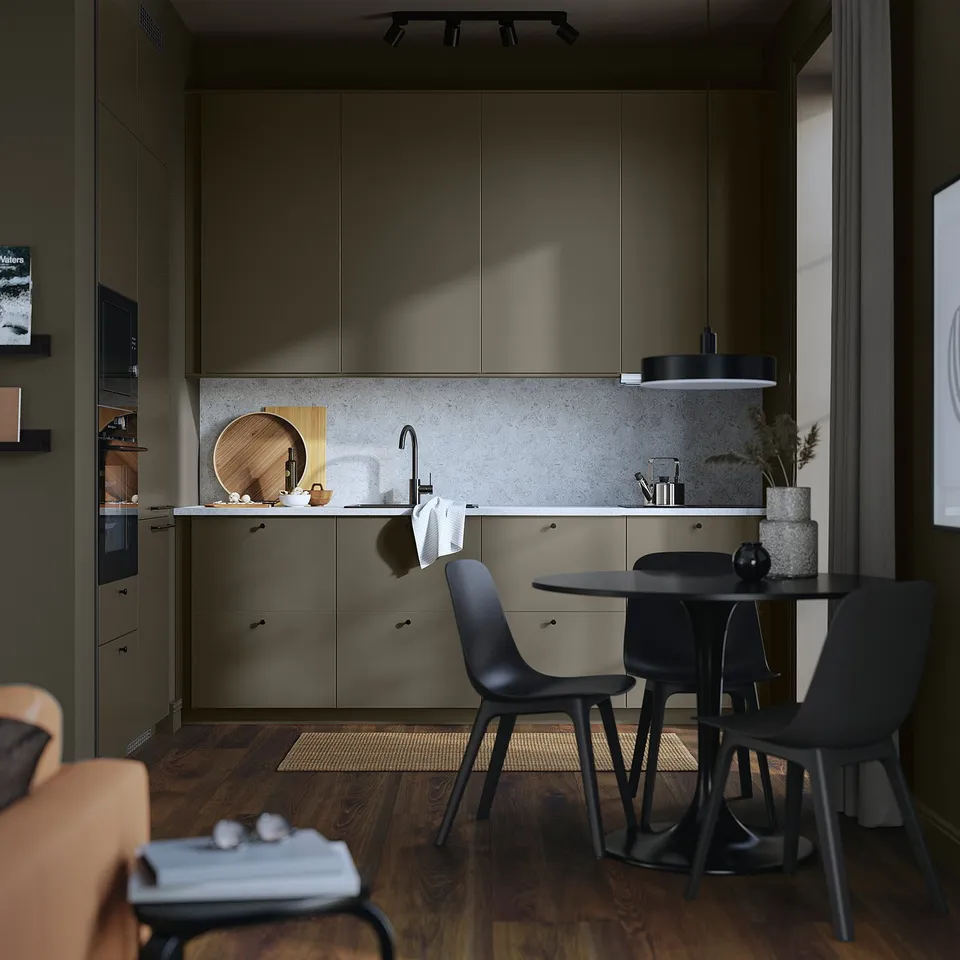 Modern kitchen with dark brown cabinets, light countertop, black chairs, wooden floor, and minimalist decor.