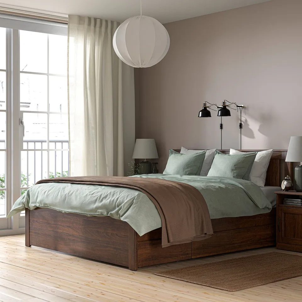 Cosy bedroom with SONGESAND bed, green bedding, brown blanket, black lamps, large window, and neutral decor.