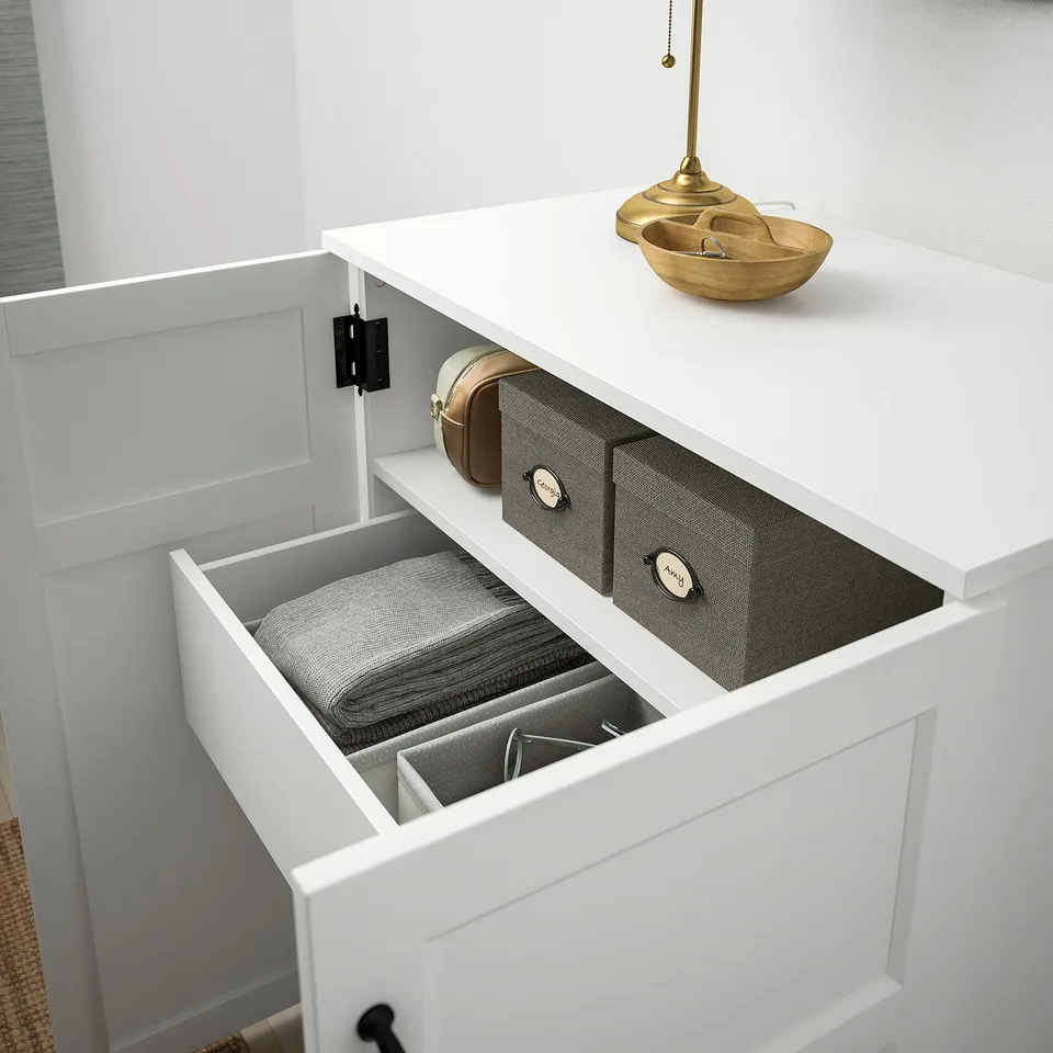 White cabinet with open drawers showing grey fabric organisers and accessories, demonstrating efficient storage solution.