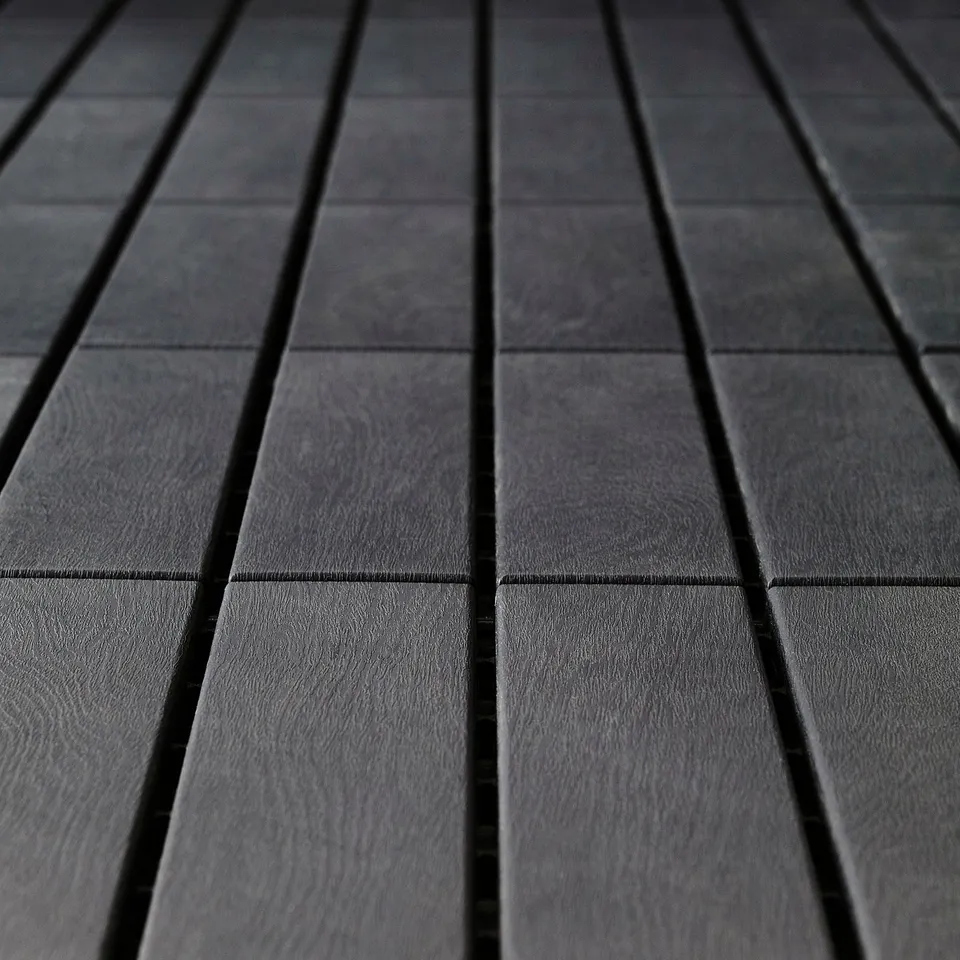 Dark grey polypropylene floor decking tiles arranged in parallel rows, creating a sleek, weather-resistant pattern.