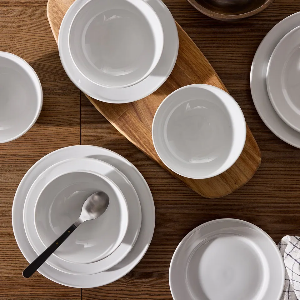 White VARDAGEN dishes elegantly arranged on wooden table.