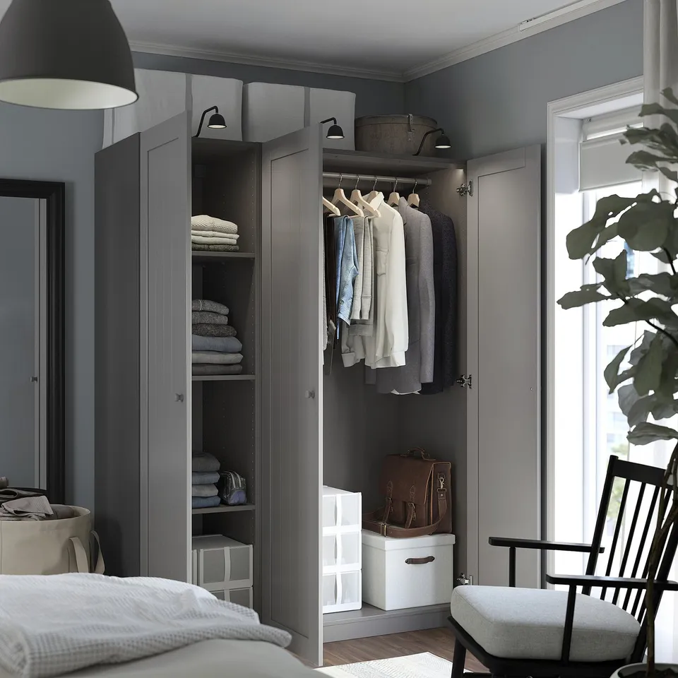 Modern walk-in closet with grey doors open, revealing neatly organised clothes and towels. Built-in lighting highlights the space.