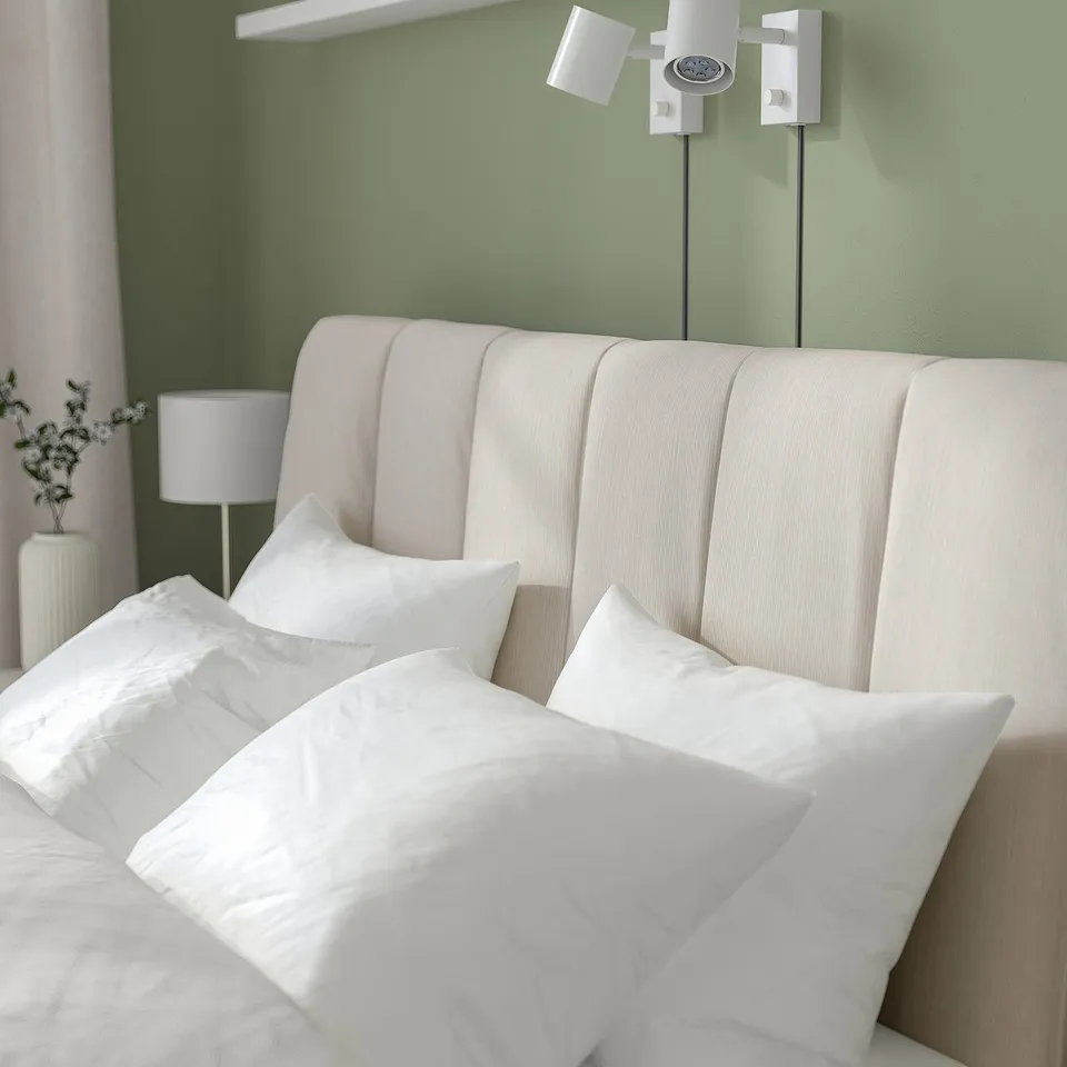 Modern bed with adjustable sides, soft headboard, and neutral colour scheme.