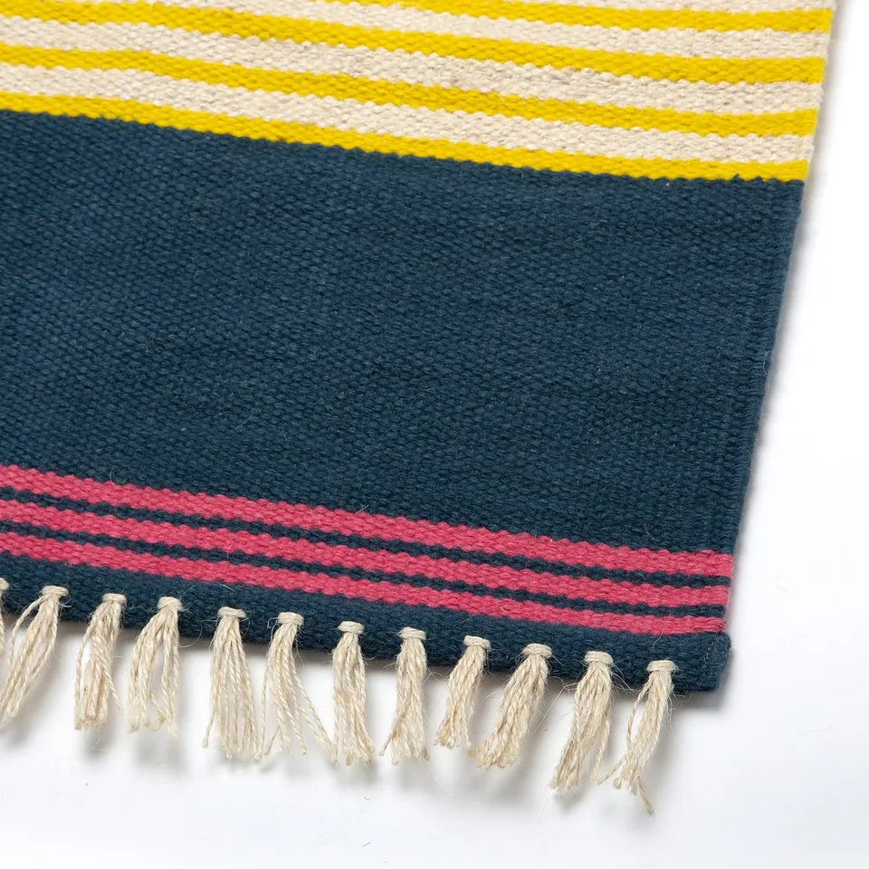 Handwoven jute rug with colourful wool stripes and fringe.