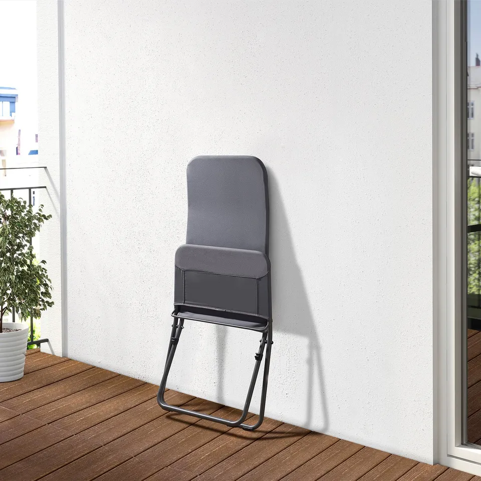Foldable lounge chair leaned against white wall, perfect for outdoor relaxation.