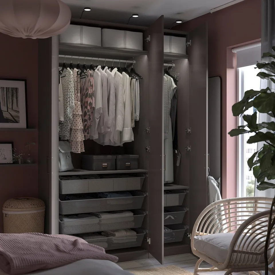Open wardrobe with clothes, featuring black shelves and hanging space.