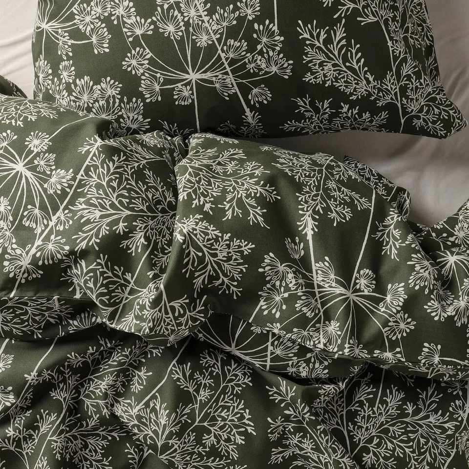 Fresh green bedding with white floral pattern, soft and textured.