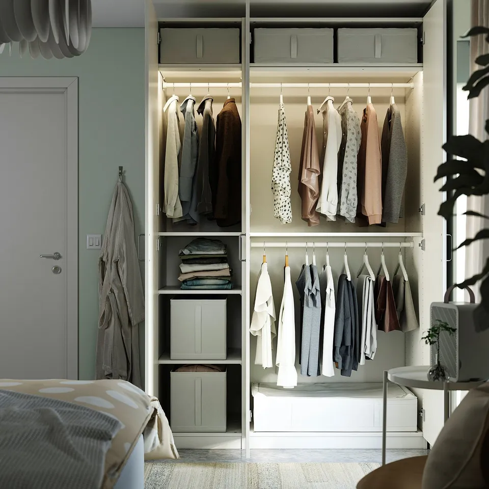 A wardrobe with clothes organised in hanging sections, shelves, and storage bins. Top boxes illuminate garments beneath.