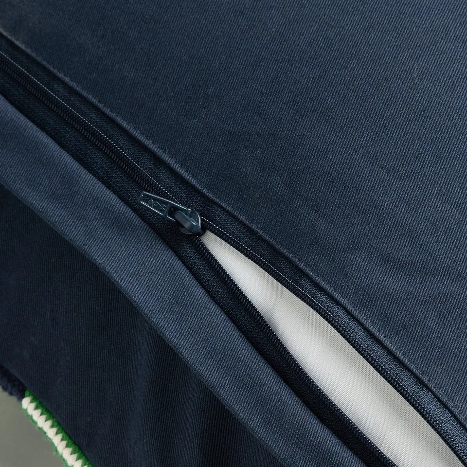Close-up of zip on dark cushion cover, showing opening detail.
