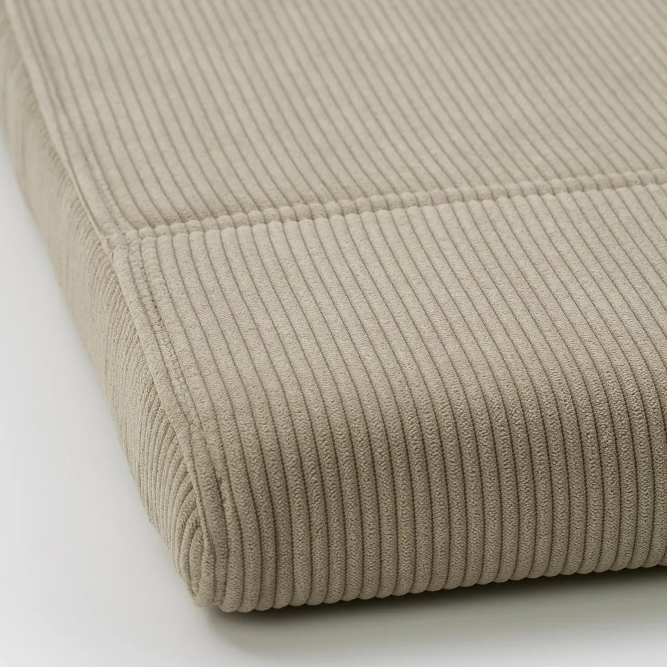 Close-up of soft, ribbed beige POÄNG cushion, showcasing its texture and stitching detail.