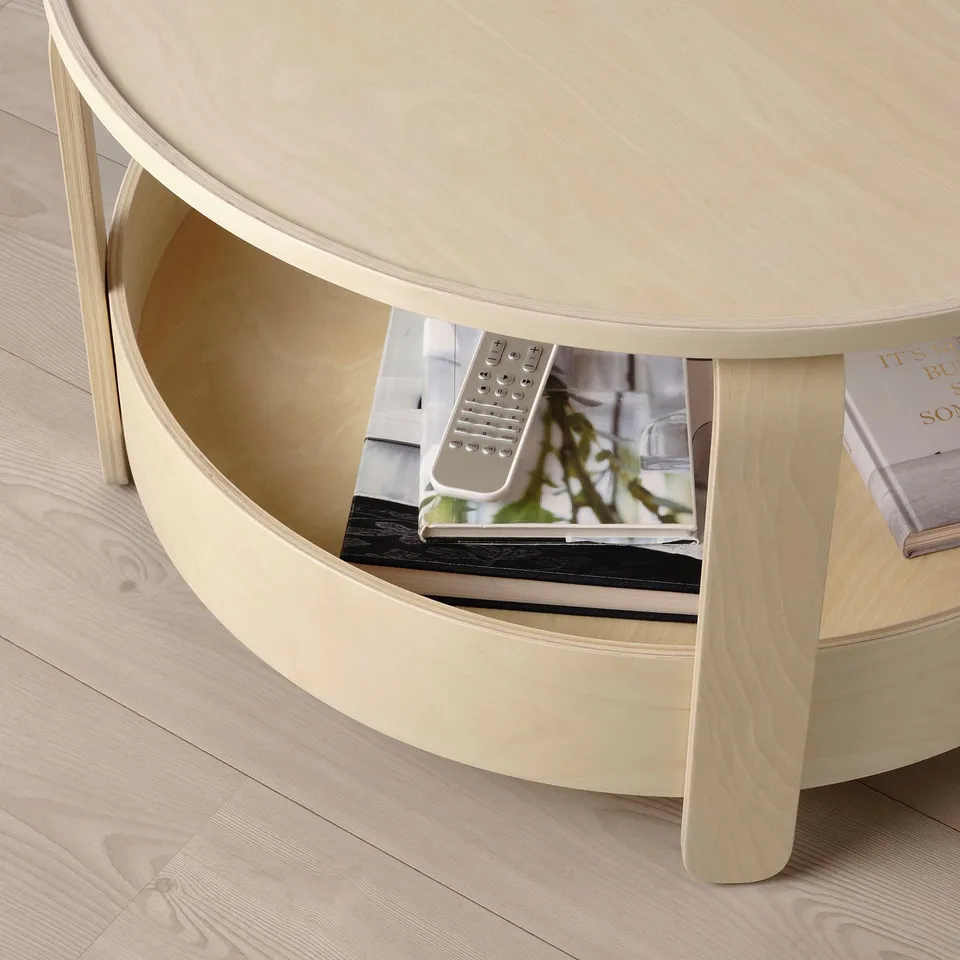 Light wooden round coffee table with open shelf. Remote, books, and magazine stored underneath.