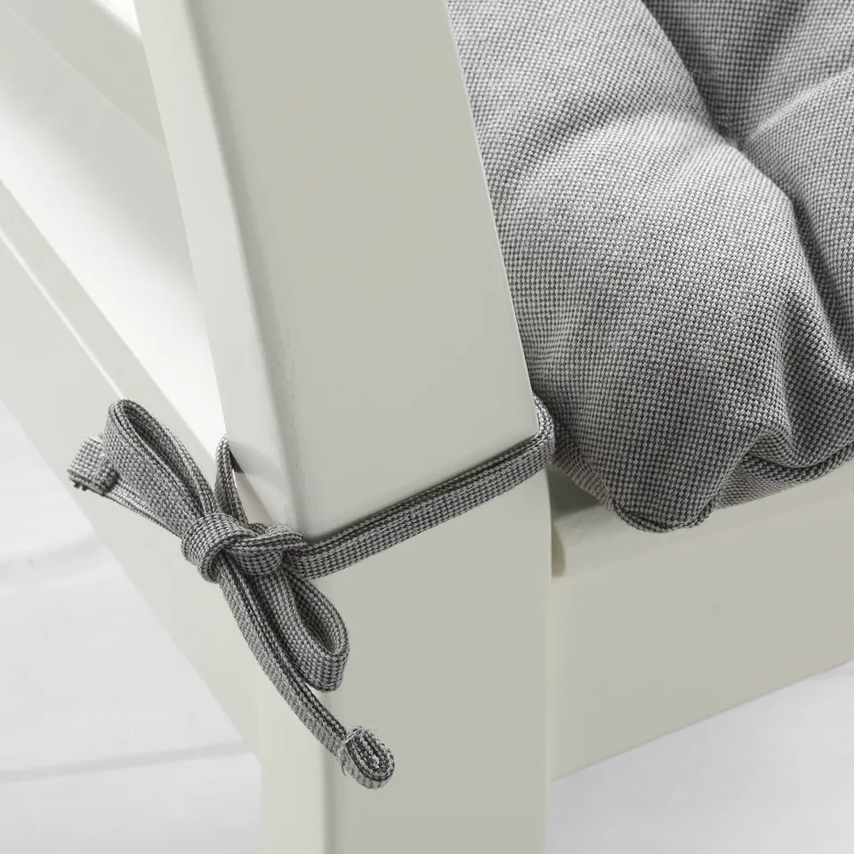 Chair pad with thick cushion, decorative fabric ties.