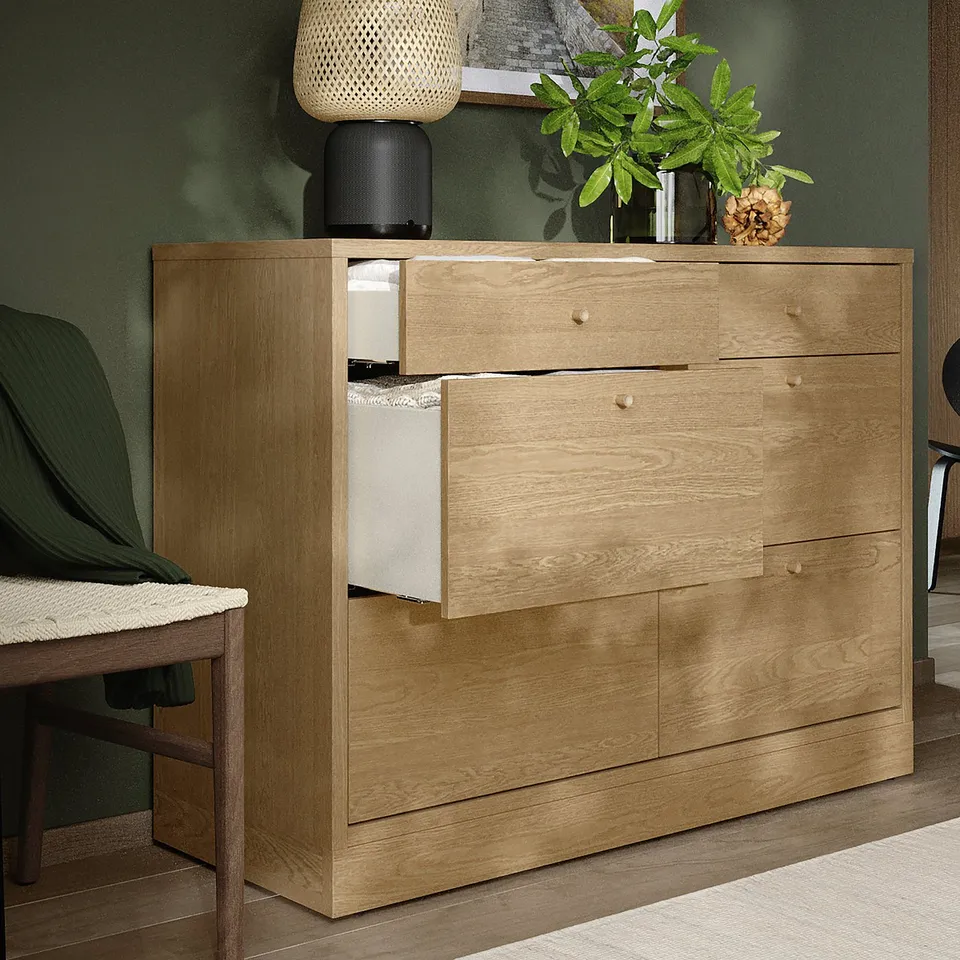 Wooden dresser with open and closed drawers, featuring oak knobs, set against green wall.